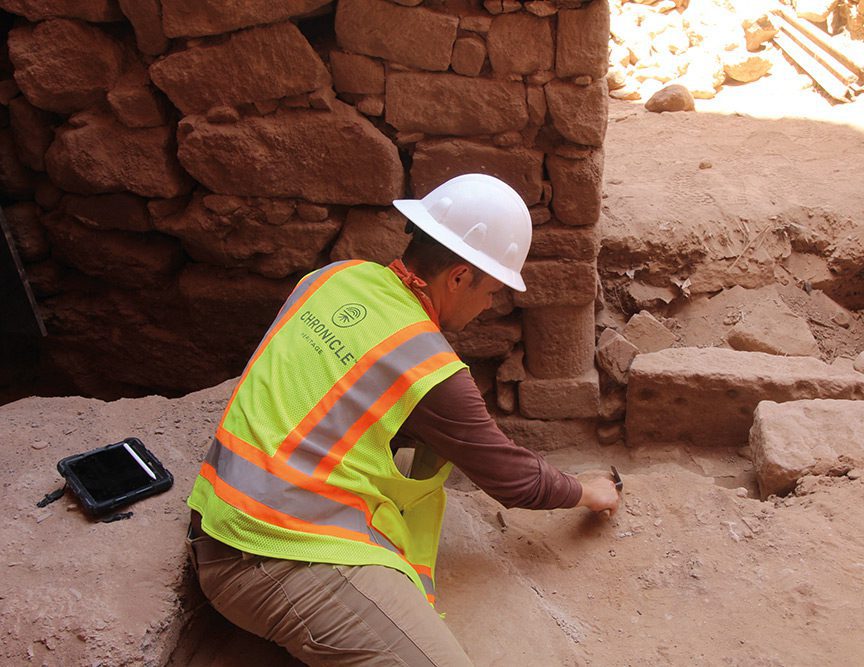 an archaeologist scraping a rockface