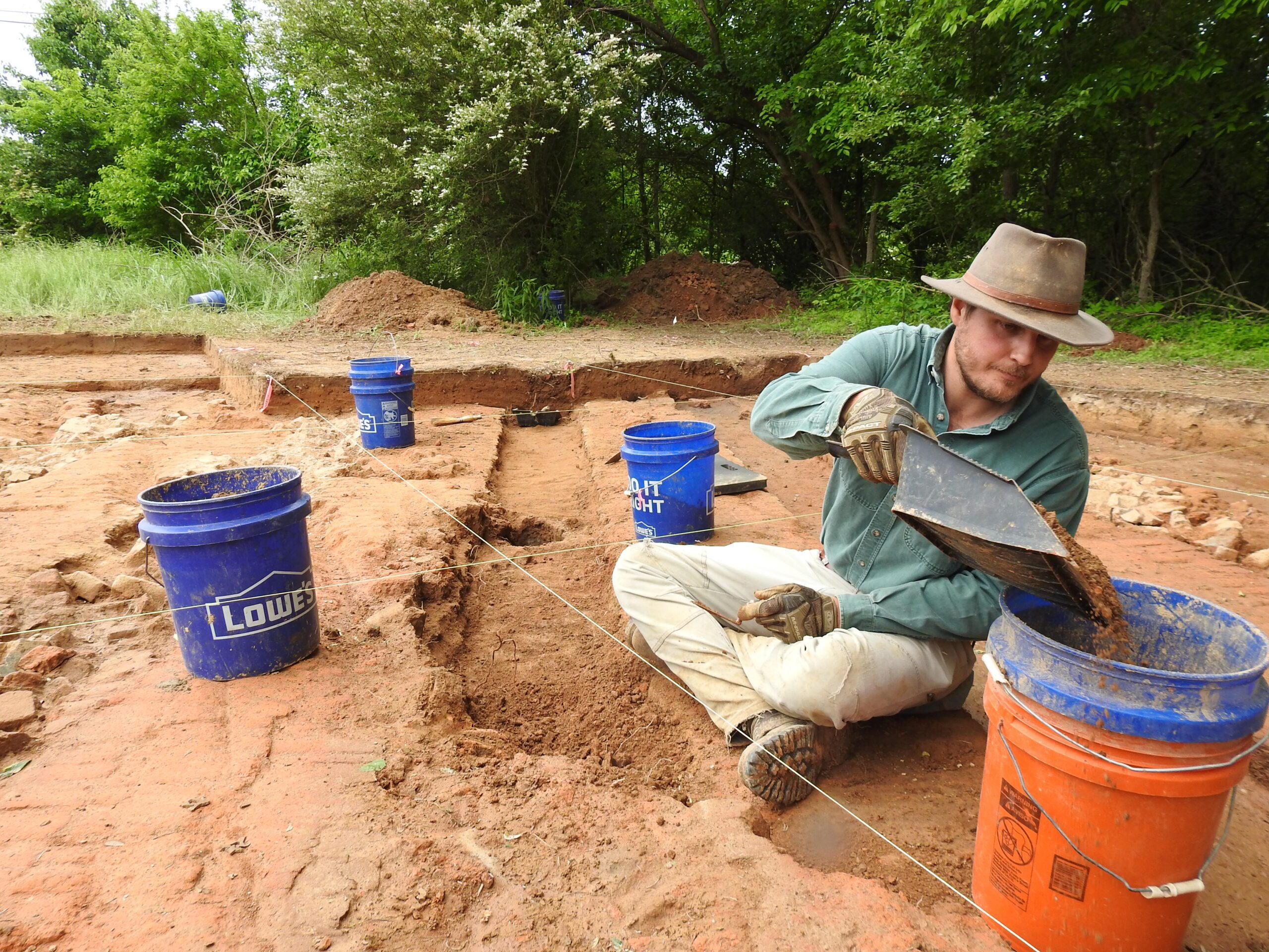 A Chronicle Heritage archaeologist digs out a channel at a brick kiln site in northern Mississippi.