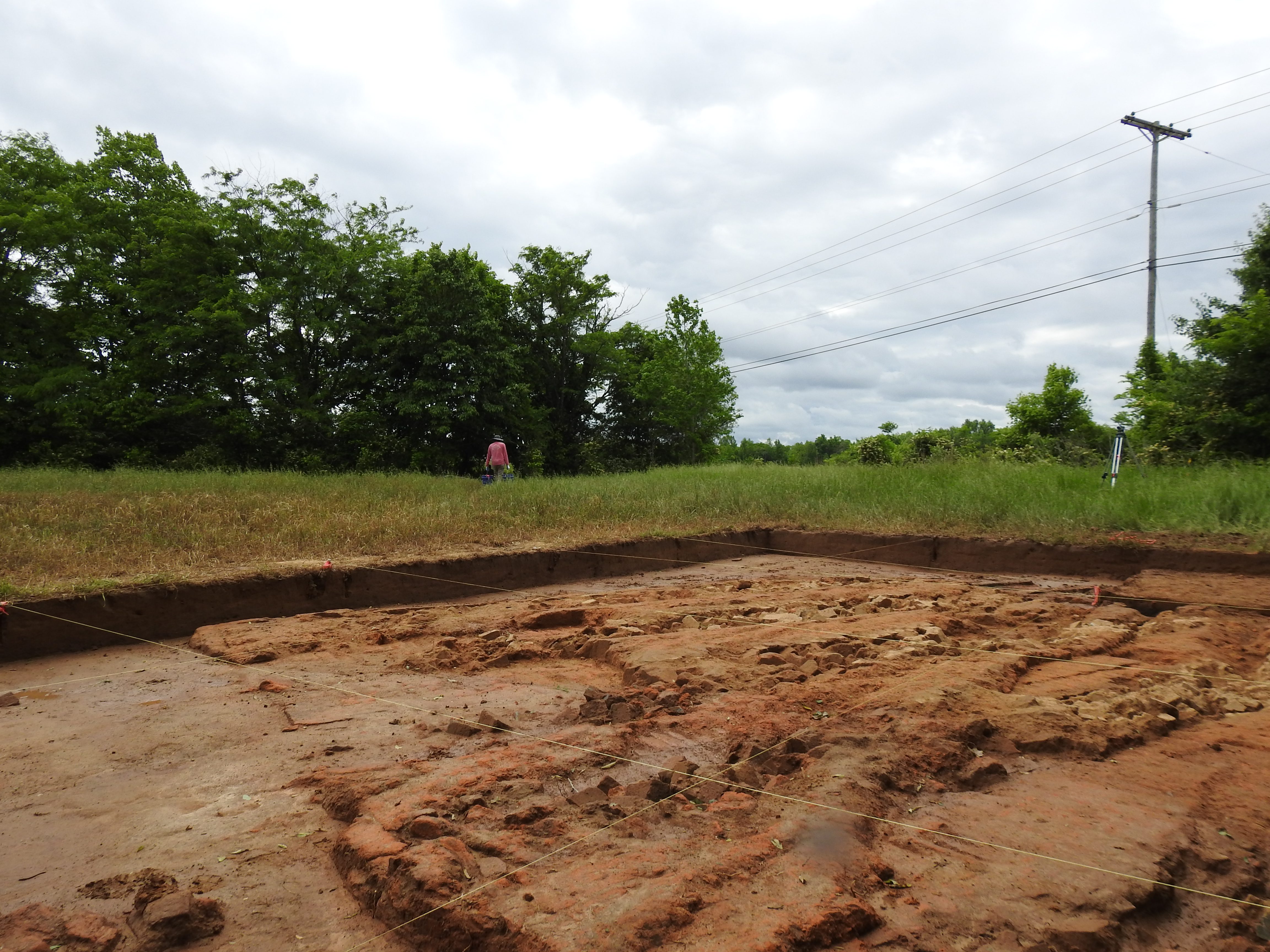 A Chronicle Heritage archaeologist hauls bricks from the site in a bucket.
