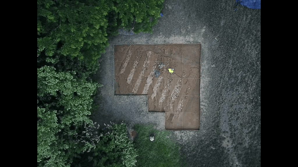 A top down view of the brick kiln project site, with distinctive brick foundation columns and dirt channels.