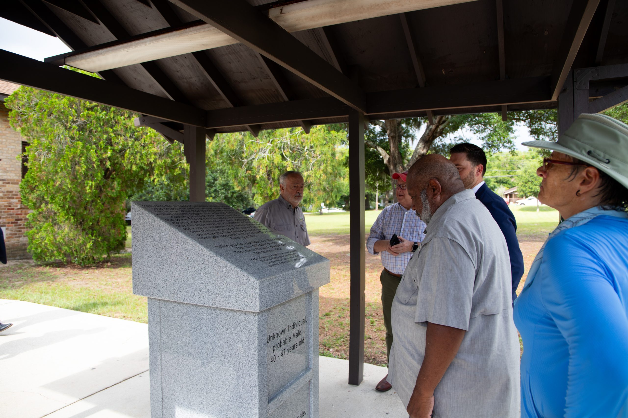 Burial Marker at Miraflores Park A citizen reads the burial marker for two unidentified individuals found beneath a building a Miraflores Park.