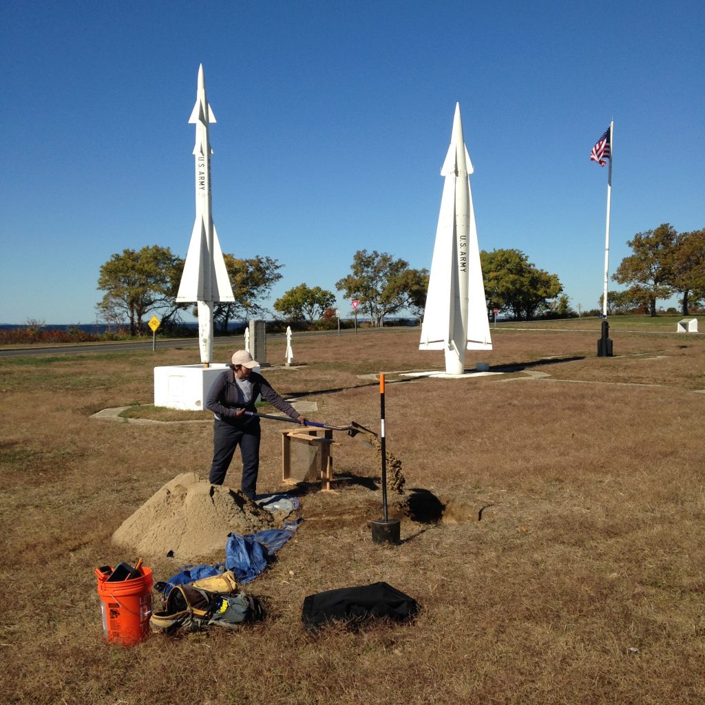 A Chronicle Heritage archaeologist digs a shovel test pit on a U.S. naval base.