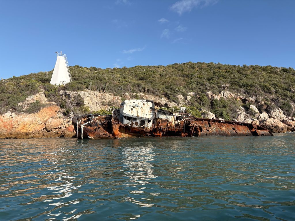 Large modern crew vessel likely abandoned along the shoreline of Salt Pan Hill across Kingston Harbour from Port Royal, Jamaica. Recent marine remote-sensing survey operations ran nearby this derelict wreckage and white aid to navigation (ATON) onshore. Photo courtesy of Matt Hanks